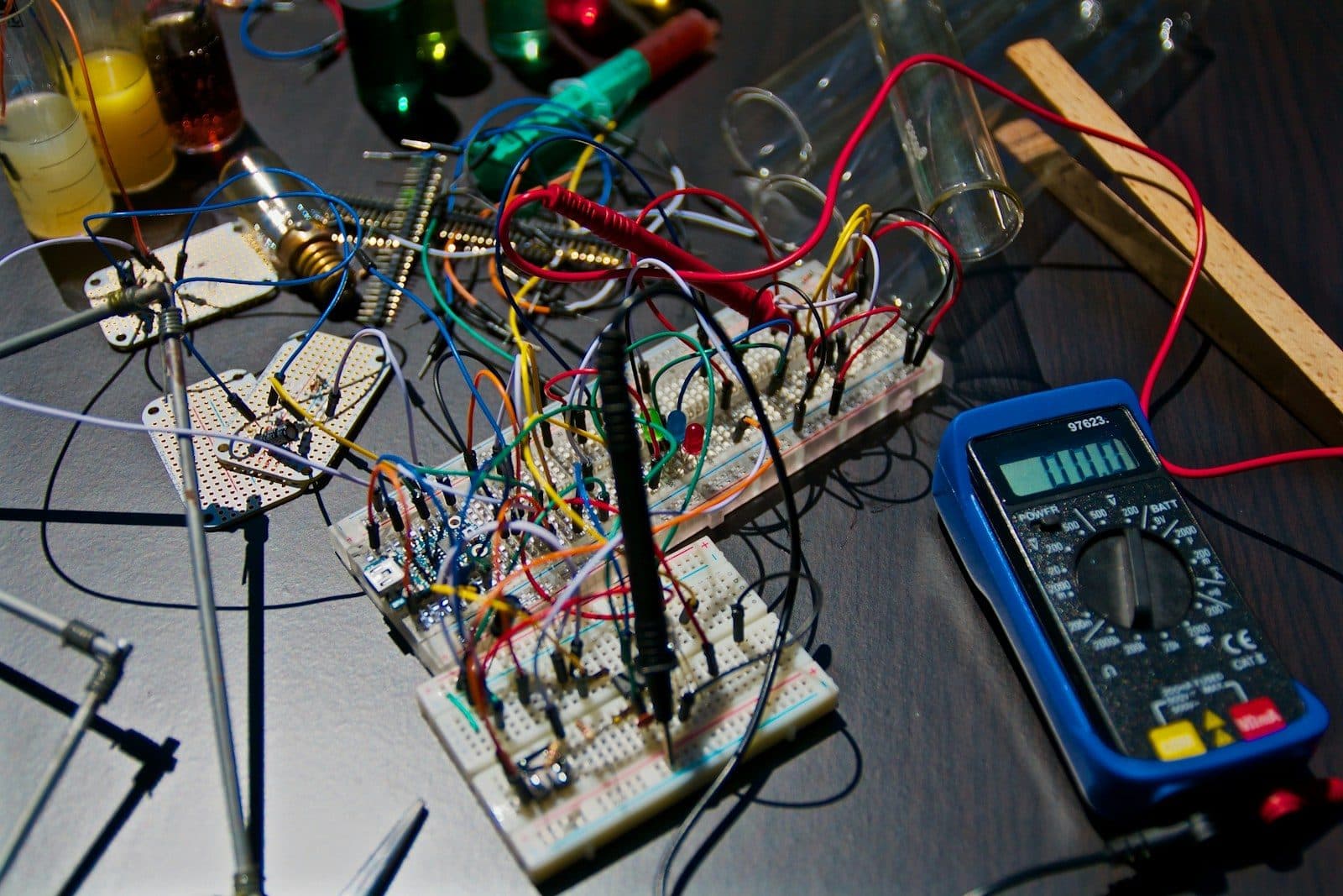 Circuit electronic pe o placă de test, cu fire și un multimetru digital