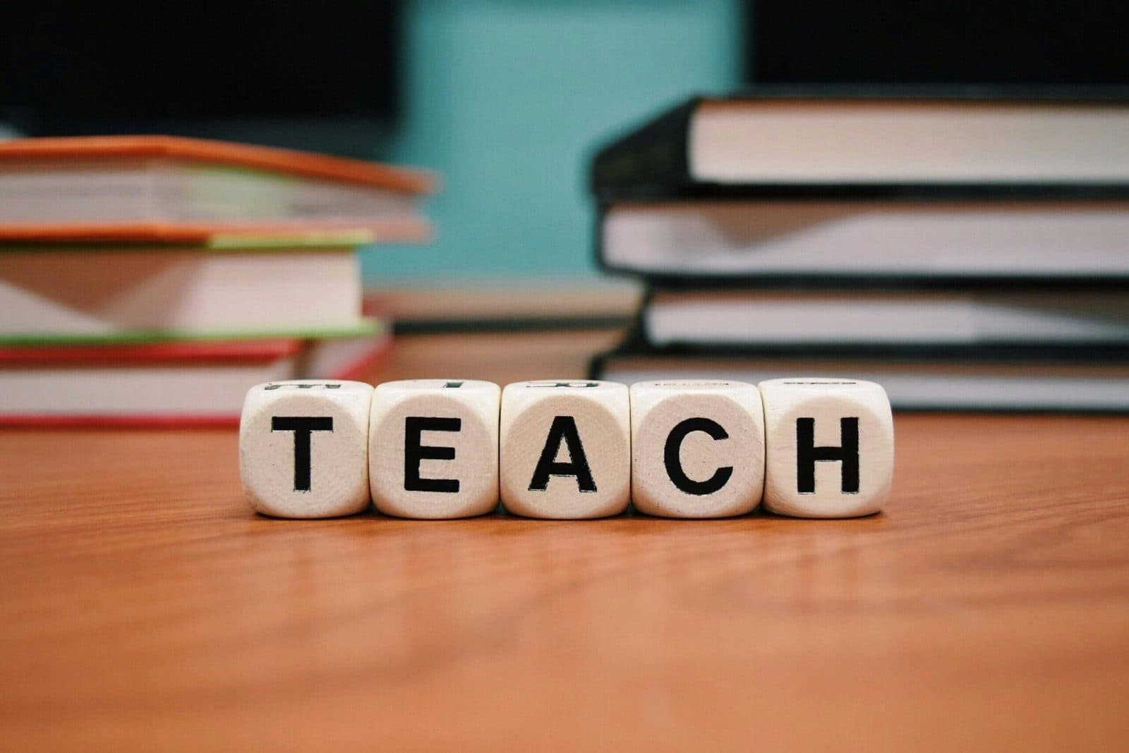 Zaruri cu inscripția TEACH în fața unui teanc de cărți